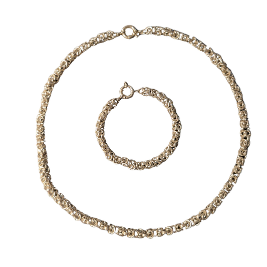 Handmade Byzantine chain and matching bracelet set in precious metal on a white background
