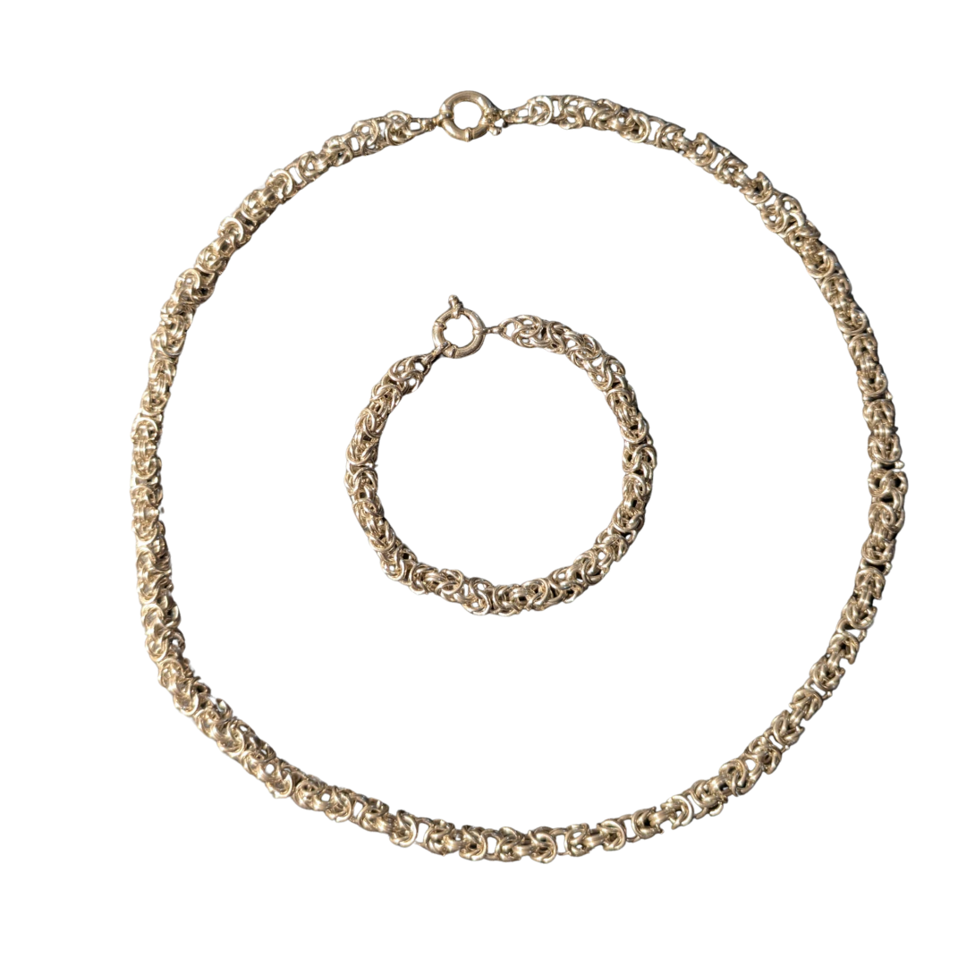 Handmade Byzantine chain and matching bracelet set in precious metal on a white background