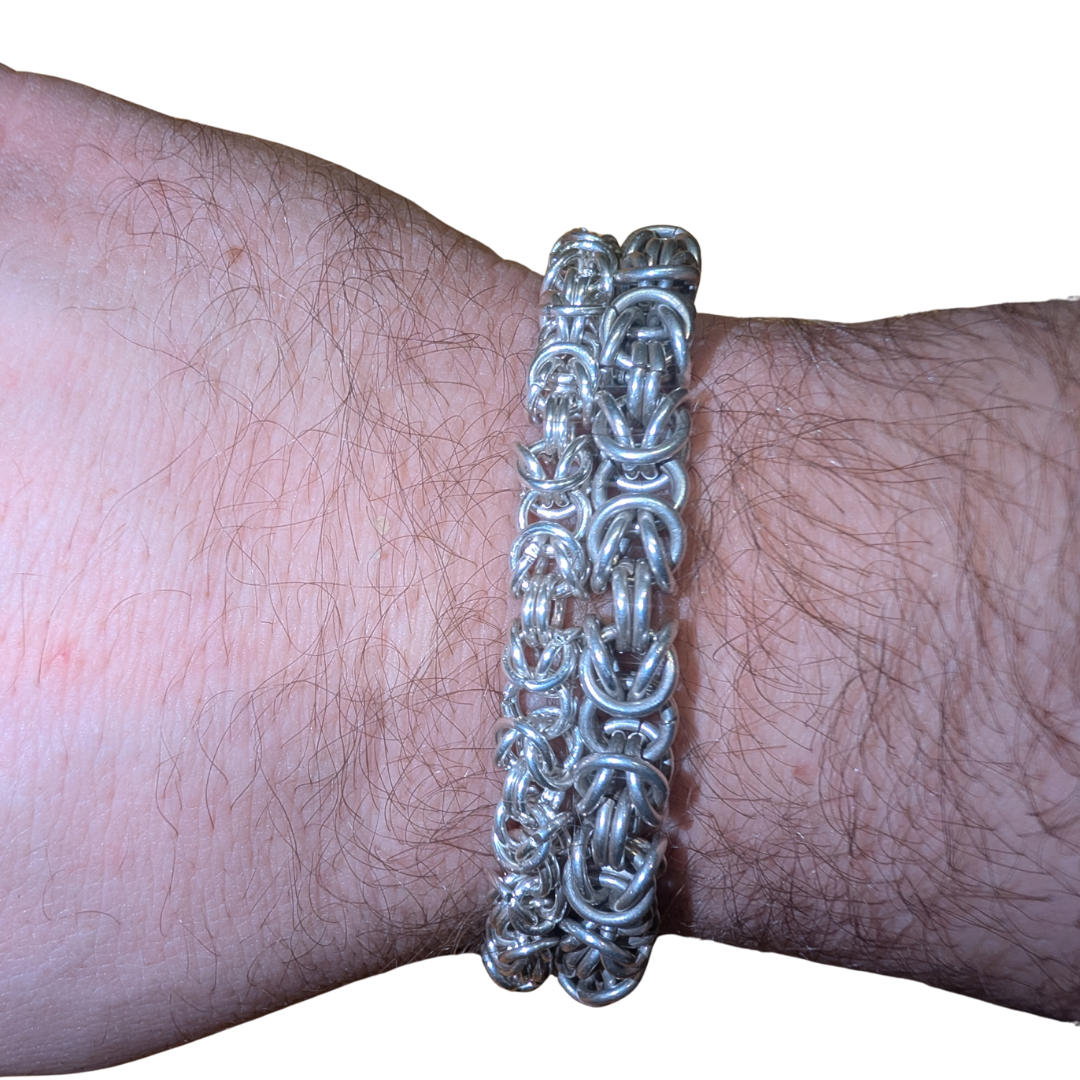 Two handmade sterling silver Byzantine bracelets worn on a wrist, showing thickness and structure