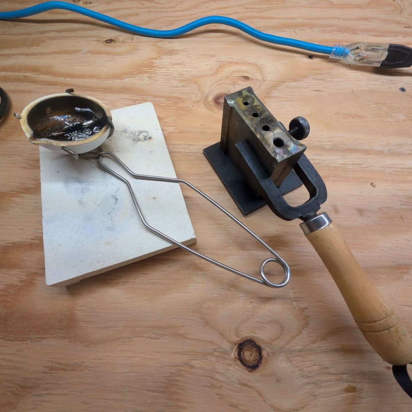 Butane torch and metal clamp on a wooden surface