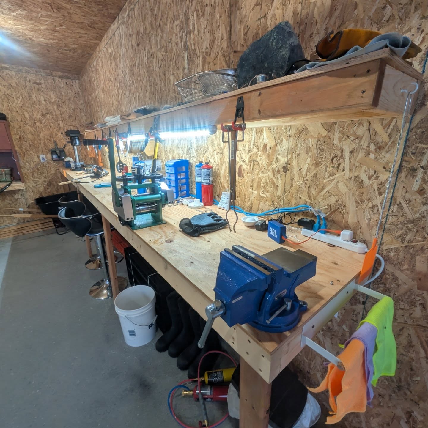 Workshop with tools and equipment on a wooden workbench.